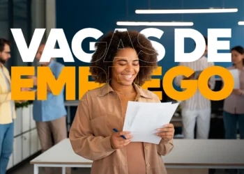 Mulher jovem de cabelos cacheados sorrindo enquanto analisa papéis em um escritório moderno, com o texto "VAGAS DE EMPREGO" sobreposto em cores branco e laranja.