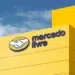 Prédio amarelo do Mercado Livre com logotipo de mãos apertadas e céu azul ao fundo